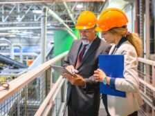 two people in hard hats in a factory setting