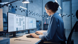 Factory Office: Female industrial engineer working on computer, on the computer screen, an industrial electronics design software.