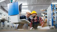 Management feature image of Quality inspector and manual worker in a factory.