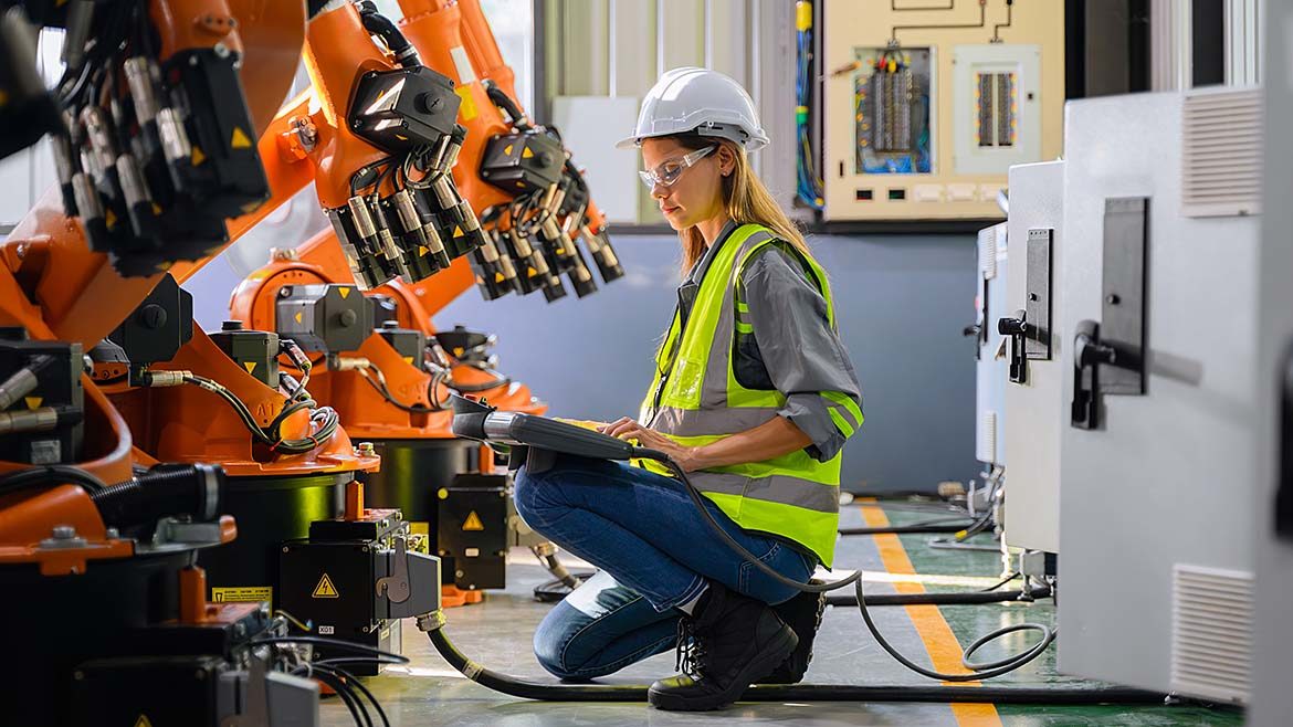 Female engineer worker working with robotic machine automation.