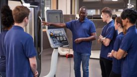 Engineer Showing Apprentices How To Use CNC Tool Making Machine.