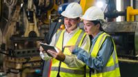 A project manager and engineer inspecting work pieces and checking standards and safety for products and safety in the factory.