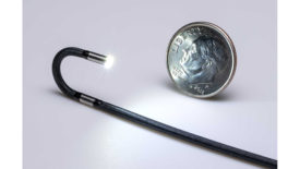 Articulated 2.2 mm OD video borescope next to a dime.