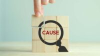 Blocks stacked in a square, pieces together form an illustration of a magnifying glass with the word "CAUSE" in the center.