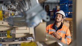 Young man industrial engineer wearing a white helmet while check the welding on the production line in the factory.