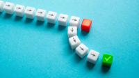 Small white dice with think black arrows, one rad with a white scribble and one green with a checkmark.