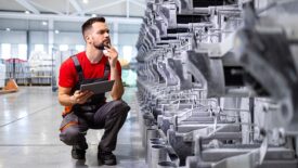 Factory worker or technician observing production machine process.