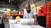 Engineer working at the factory using laptop