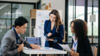 Three young business people discussing business plans in a conference room.